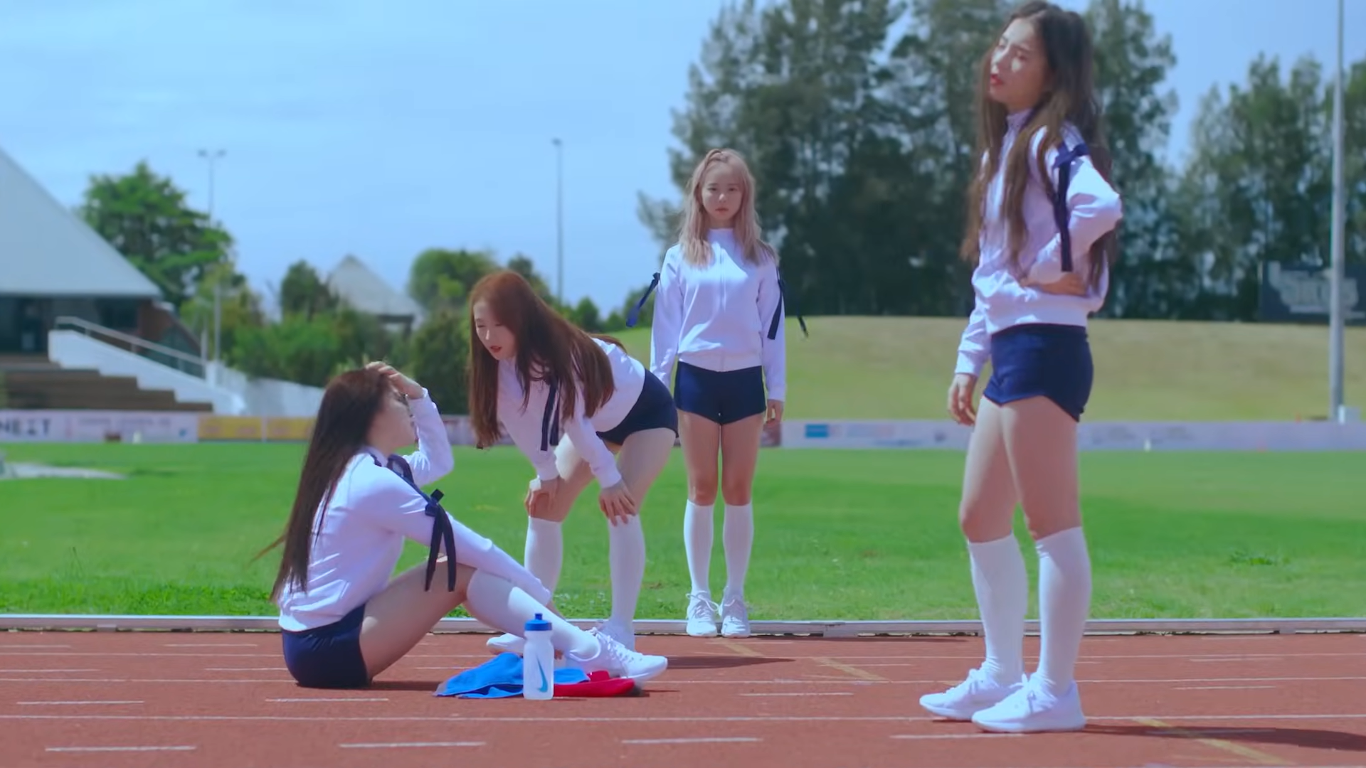Hyunjin, Haseul, Vivi, and Heejin in track uniforms, from the 'Love and Live' music video.